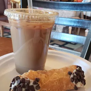 a cup of coffee and a pastry on a plate