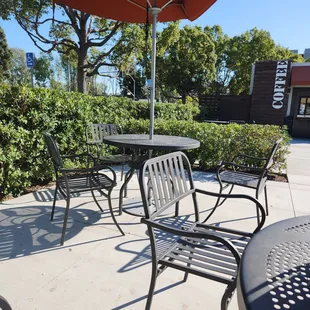 a patio with chairs and an umbrella