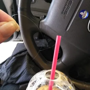 a drink in a plastic cup with a pink straw