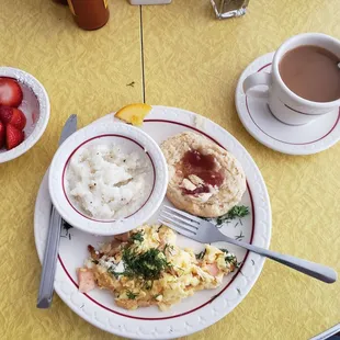 Salmon scramble with biscuit and coffee along with a side of strawberries.