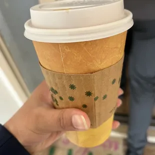 a hand holding a coffee cup