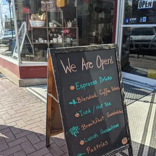 we are open sign on sidewalk
