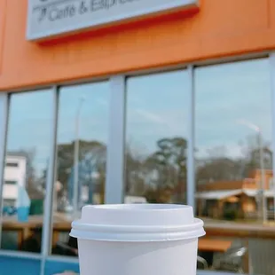 a hand holding a coffee cup