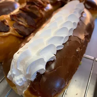 two chocolate covered donuts on a cooling rack