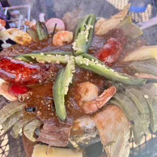 Molcajete- comes with shrimp, chicken, steak, chorizo, jalapeño, cactus, cheese, green onion, and radish all in a tangy green salsa