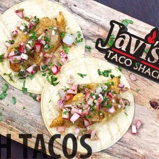 two tacos on a cutting board