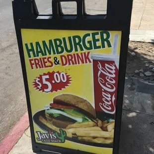 $5.00 burger, fries, and drink special sign on the sidewalk in front of the place.