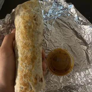 a hand holding a burrito