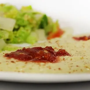 a plate of food with a side salad