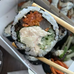 a sushi with chopsticks in a box