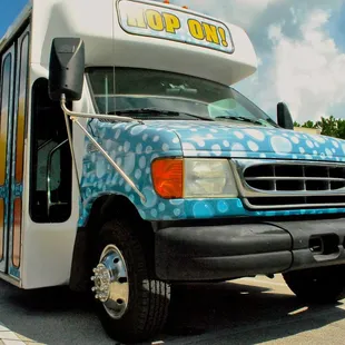 a blue and white bus parked in a parking lot