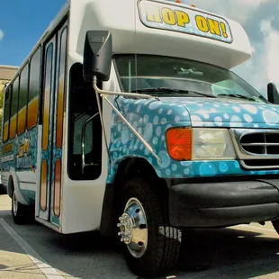 a blue and white bus parked in a parking lot