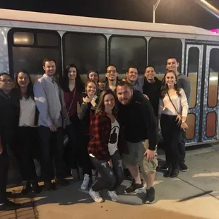 a group of people standing in front of a bus
