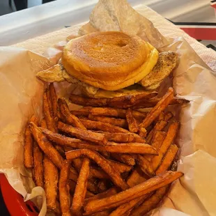 Delicious chicken sandwich with huge piece of seasoned grilled chicken breast and golden brown sweet potato fries. Absolutely delicious