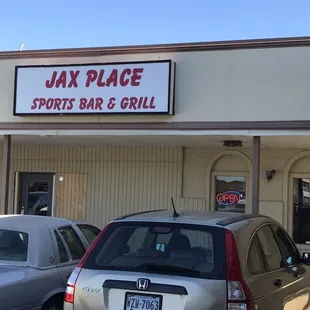 cars parked in front of a sports bar and grill