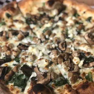 a pizza with mushrooms and spinach