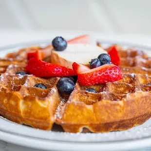 a waffle topped with strawberries and blueberries