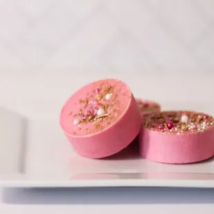 two pink cheesecakes on a white plate