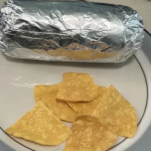 a burrito and chips on a plate