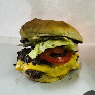a cheeseburger with lettuce and tomato