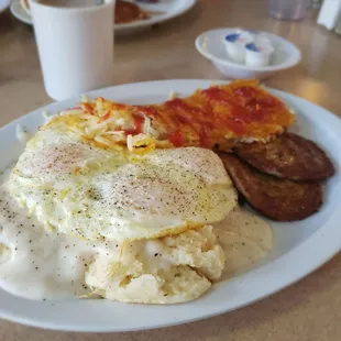 Perfect biscuits and gravy with 3 over easy eggs, sausage patties, and the yummiest hashbrowns