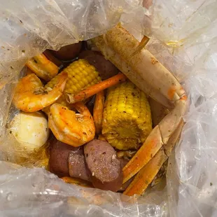 crab legs, corn, potatoes, and corn on the cob