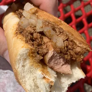 a hand holding a hot dog