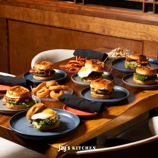 a table full of burgers and onion rings