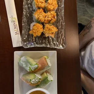 a plate of sushi rolls and a bowl of dipping sauce