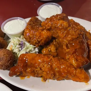 a plate of chicken wings and coleslaw