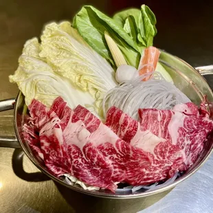 a bowl of raw meat and vegetables
