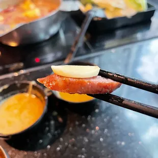 chopsticks holding a piece of meat