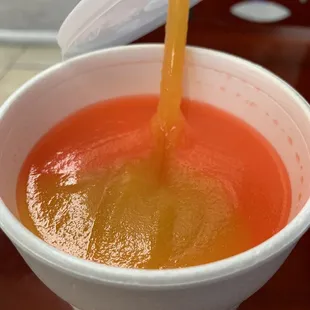 a drink being poured into a cup