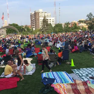 a large crowd of people sitting and standing