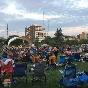 a large crowd of people sitting in lawn chairs