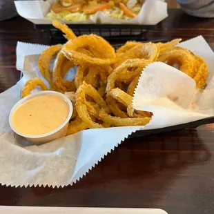 Fresh onion rings and a shrimp poboy in the background.