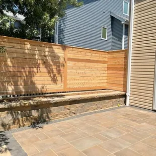 Paver patio, raised stone garden surrounded by horizontal board, solid cedar, wood fence in Walton, NE.