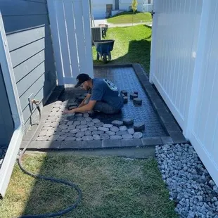 Installation of new paver patio under PVC fence in Walton, NE.
