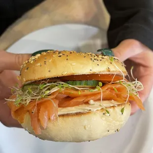 Everything bagel with cream cheese, lox, sprouts, tomatoes, and cucumbers