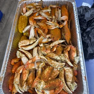 a tray of crab legs and corn on the cob