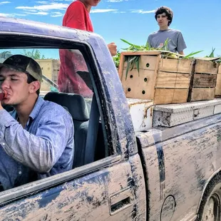 a man sitting in the bed of a pick up truck