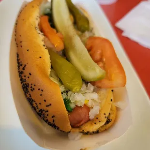 ows a hot dog with pickles and tomatoes