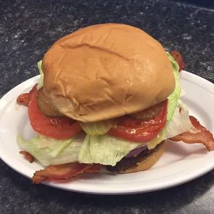a hamburger with lettuce, tomato, and bacon