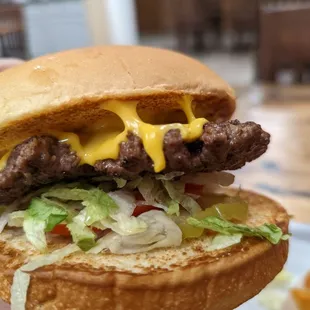 a hand holding a cheeseburger