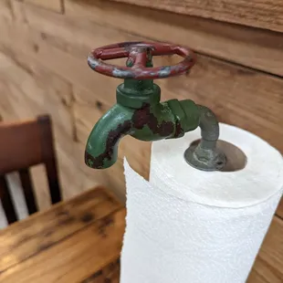 a paper towel holder with a green pipe sticking out of it