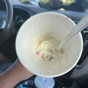 a person holding a cup of ice cream