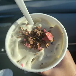 a hand holding a cup of ice cream