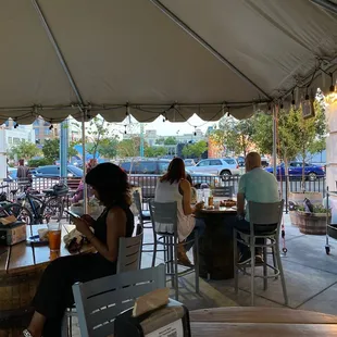 people sitting at tables under a tent