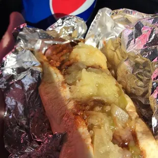 a hand holding a hot dog