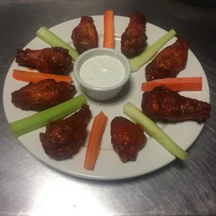a plate of chicken wings and celery sticks